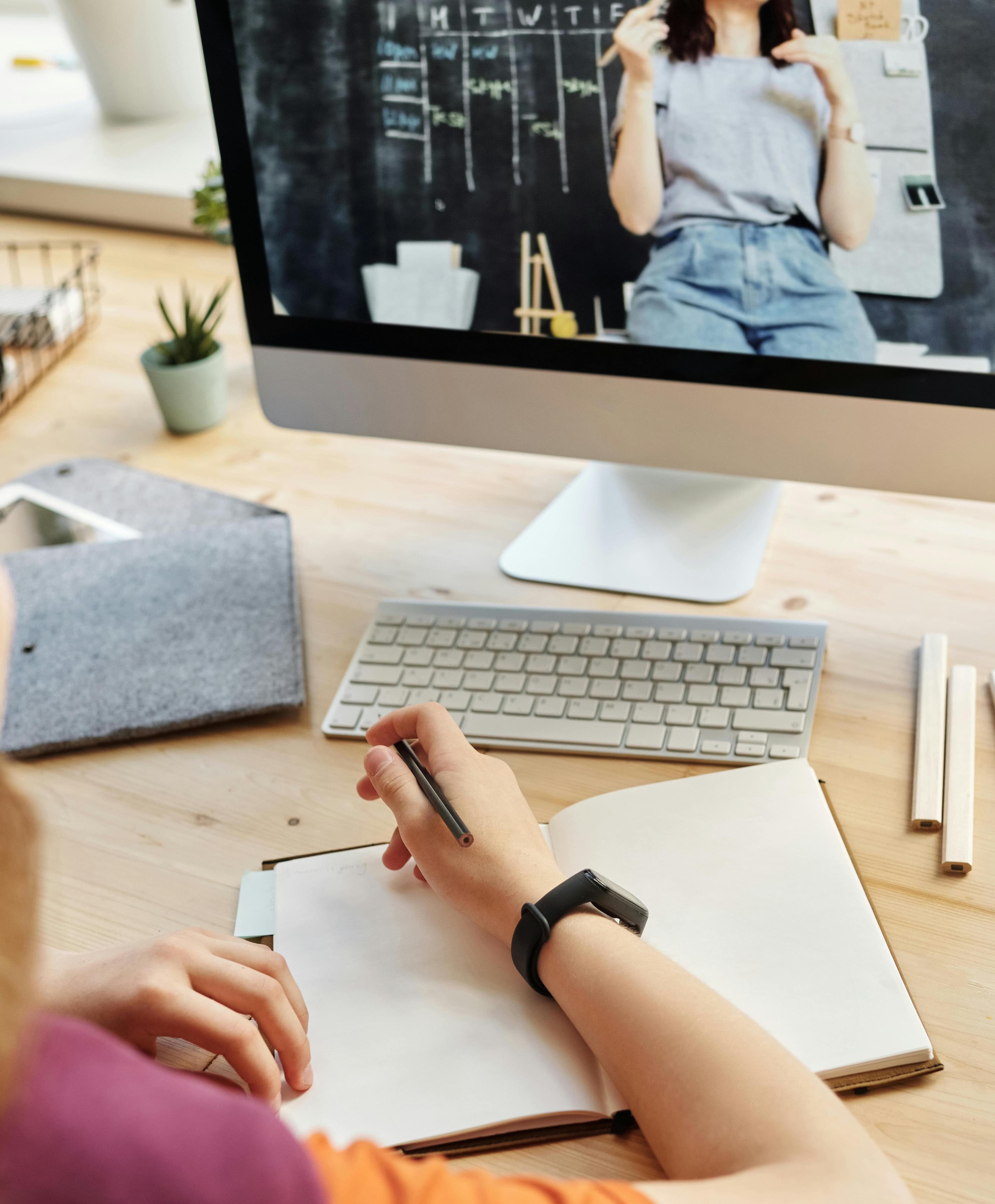 student taking notes during online tutoring session