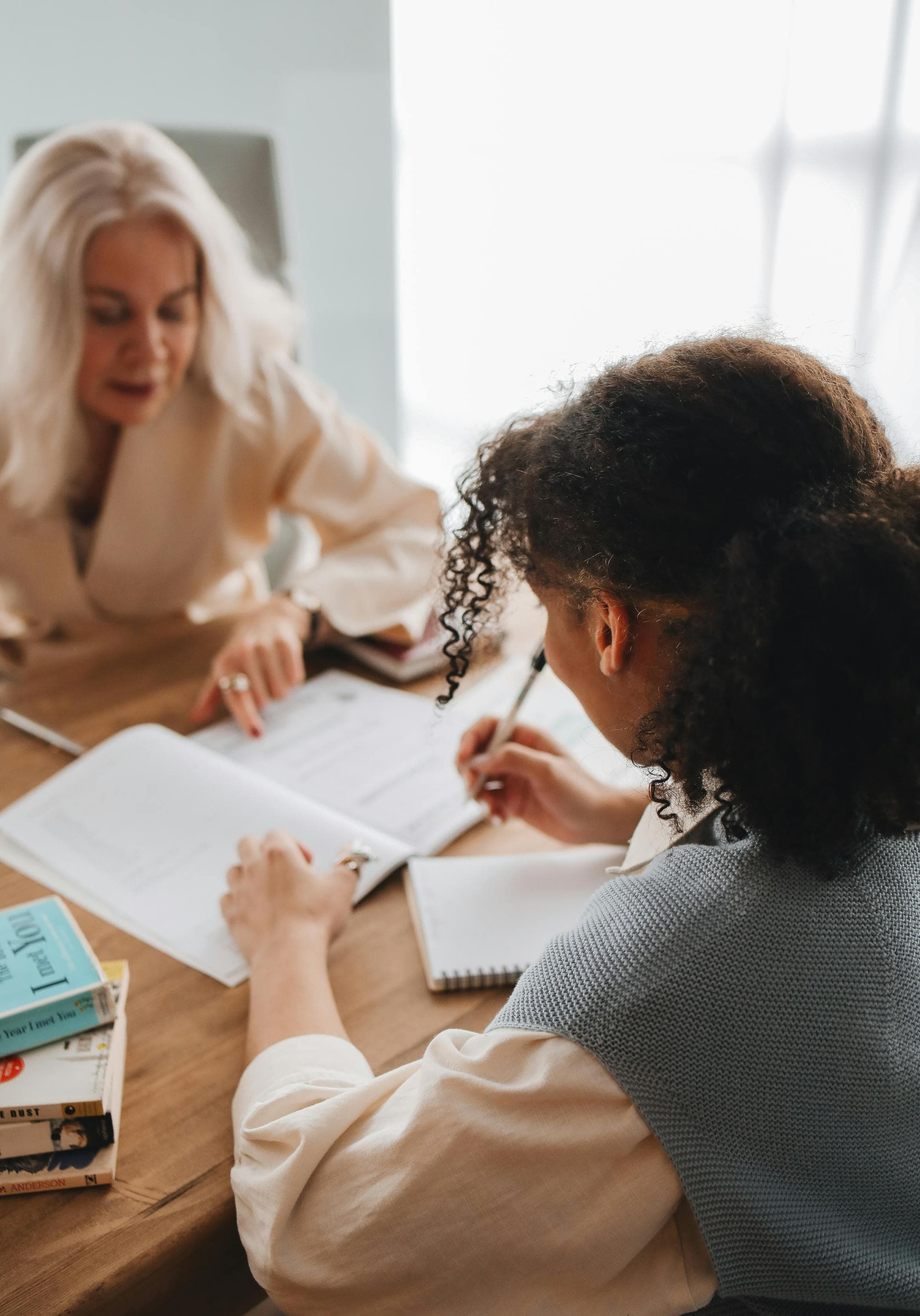 student sitting across from tutor, going over notes together